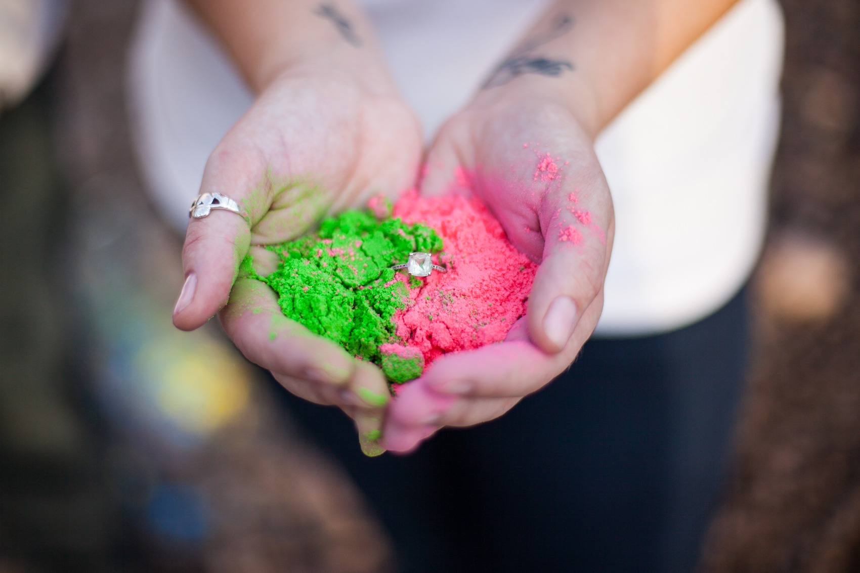 hands holding colored powder with vintage engagement ring