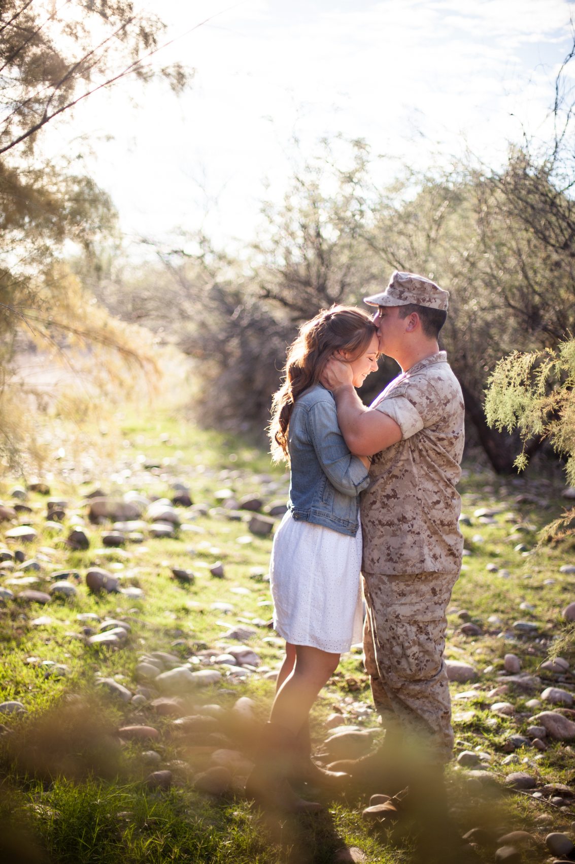 marine kissing his fiance on the forehead in the arizona desert
