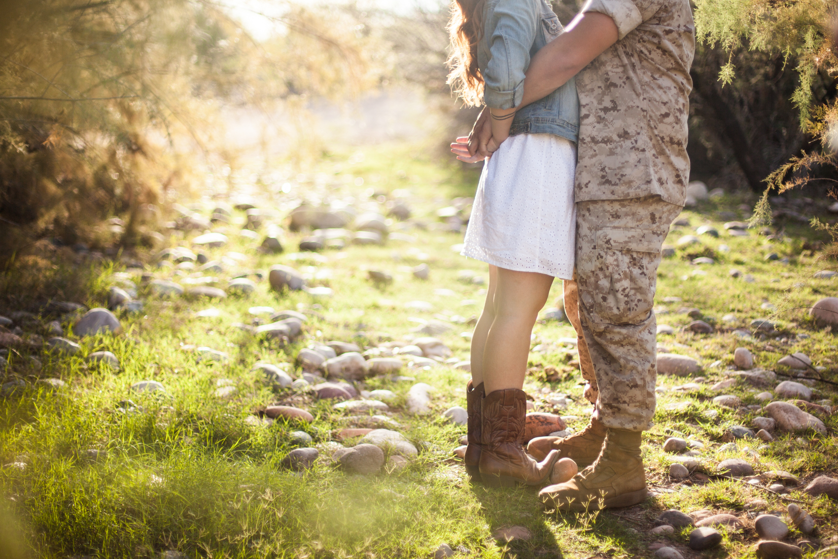 marine wrapping his arms around girl wearing cowgirl boots