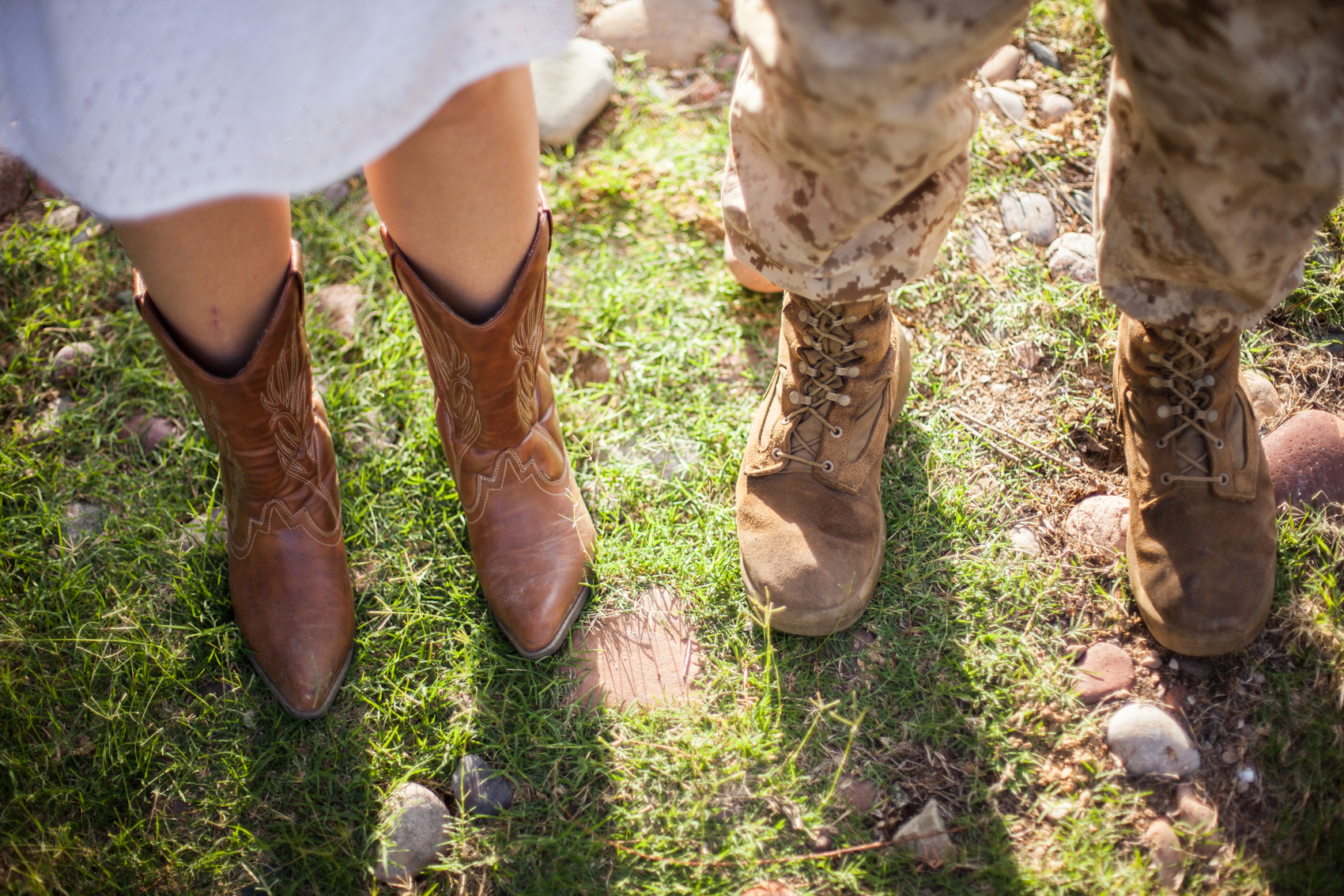 cowgirl boots and marine boots in the grass and dirt