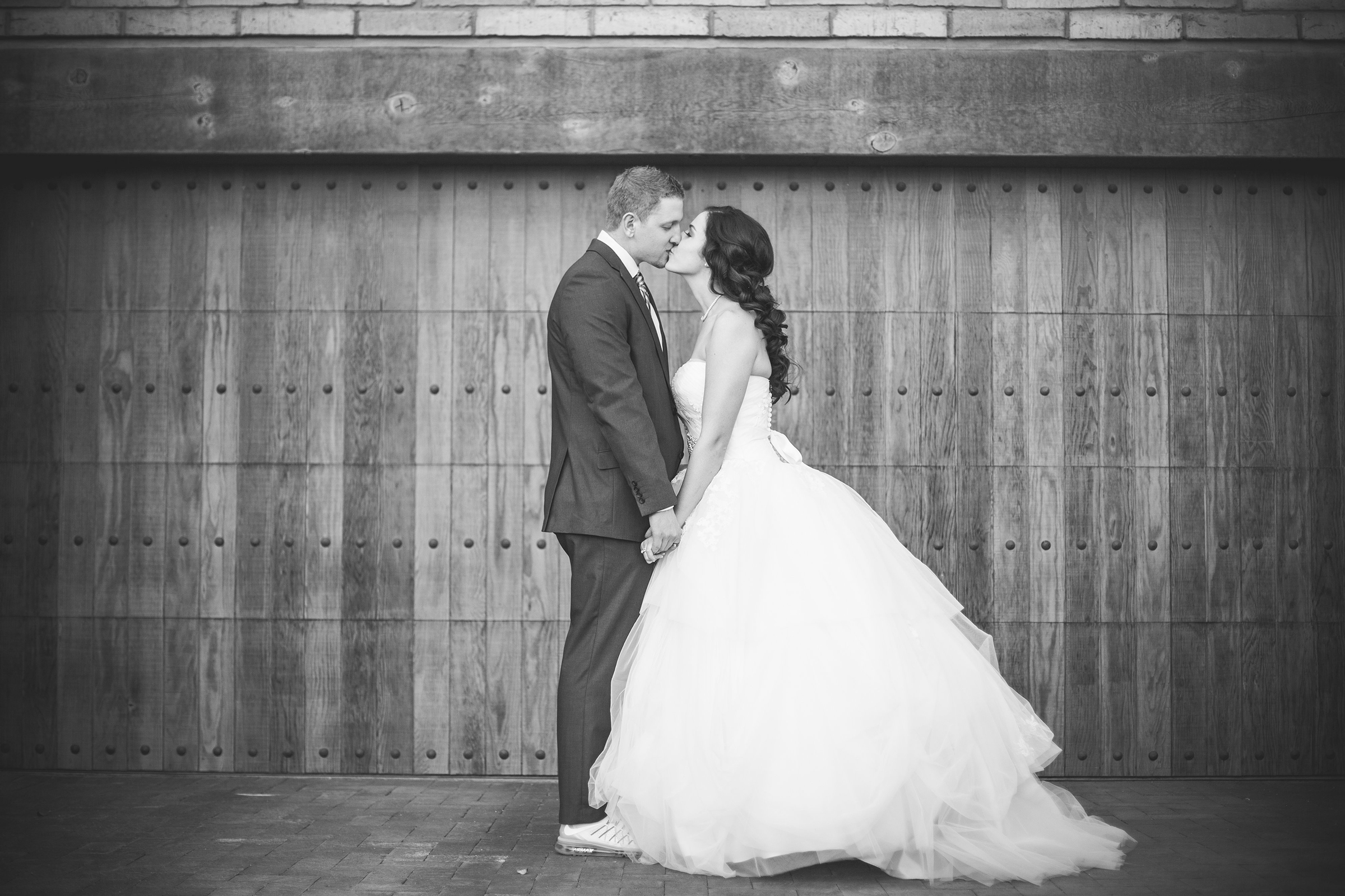 bride and groom kissing and holding hands
