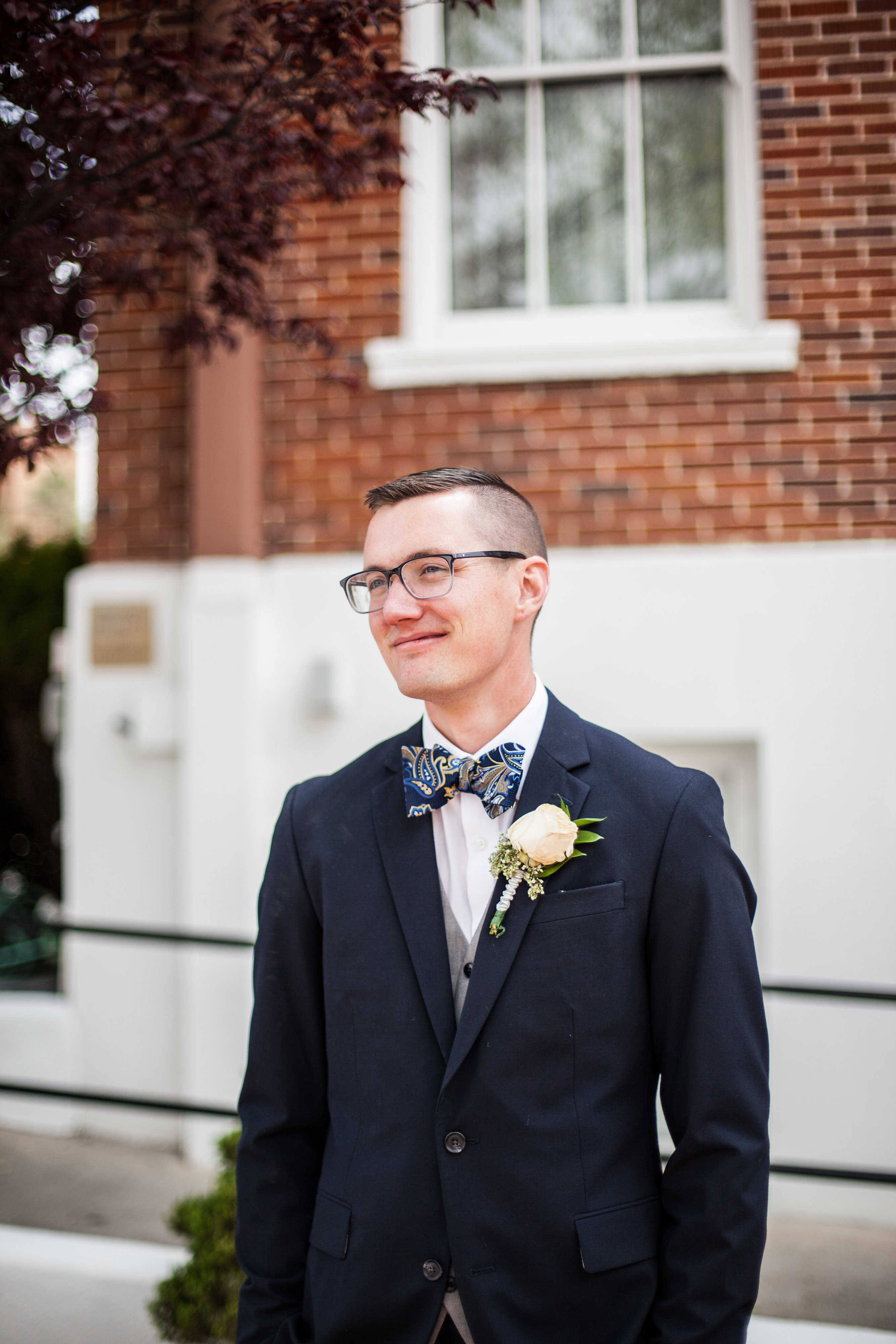 groom with navy blue suit and paisley bowtie