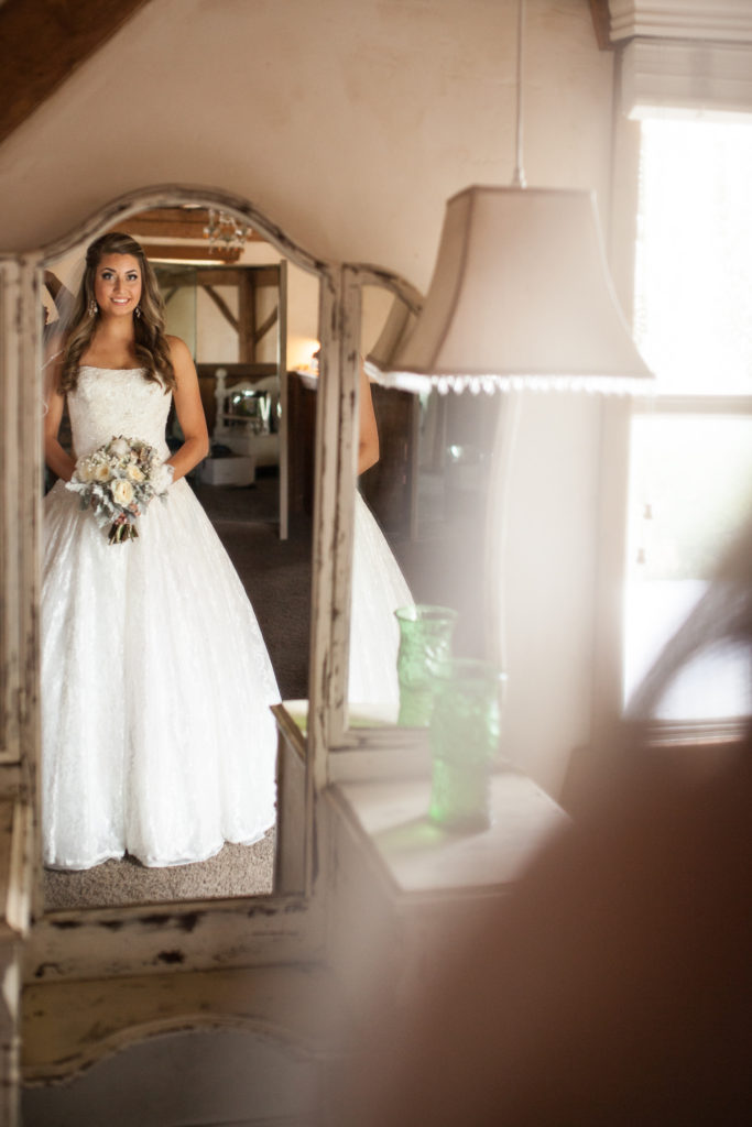 rustic bride looking in the mirror