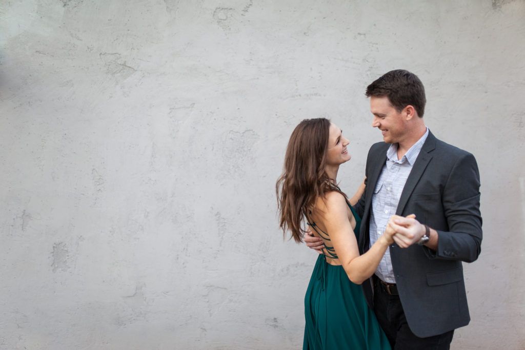 downtown phoenix engagement photos engagement pictures engagement photographer long flowy green dress from lulus for engagement session with gray background dancing couple engagement pictures inspiration