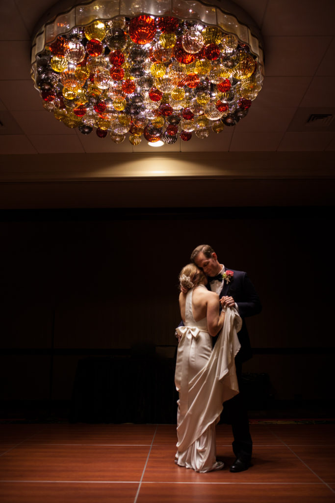 first dance bride and groom under blown glass