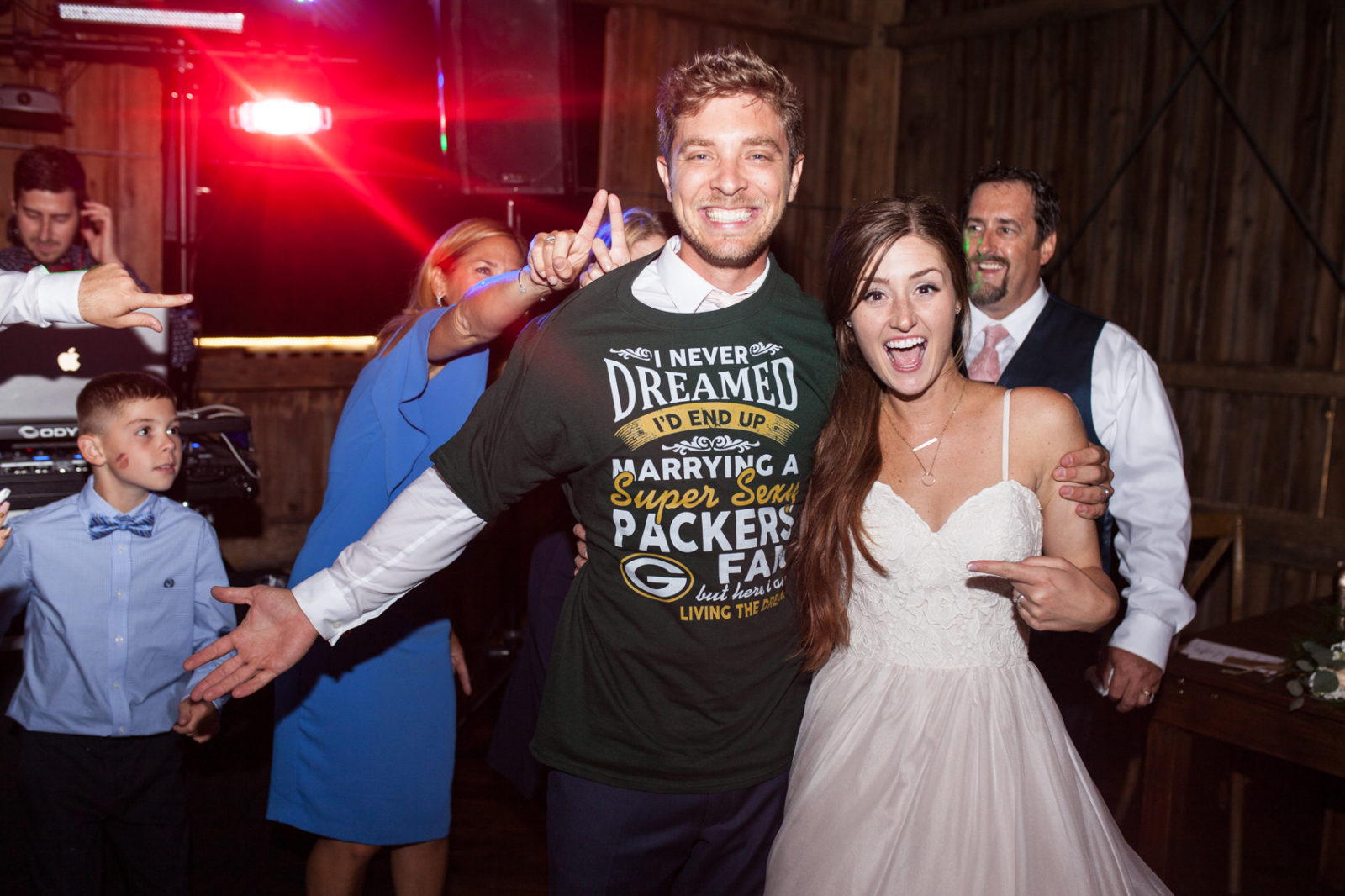 wedding reception in the barn of The Farm at Dover packers fan t shirt for groom