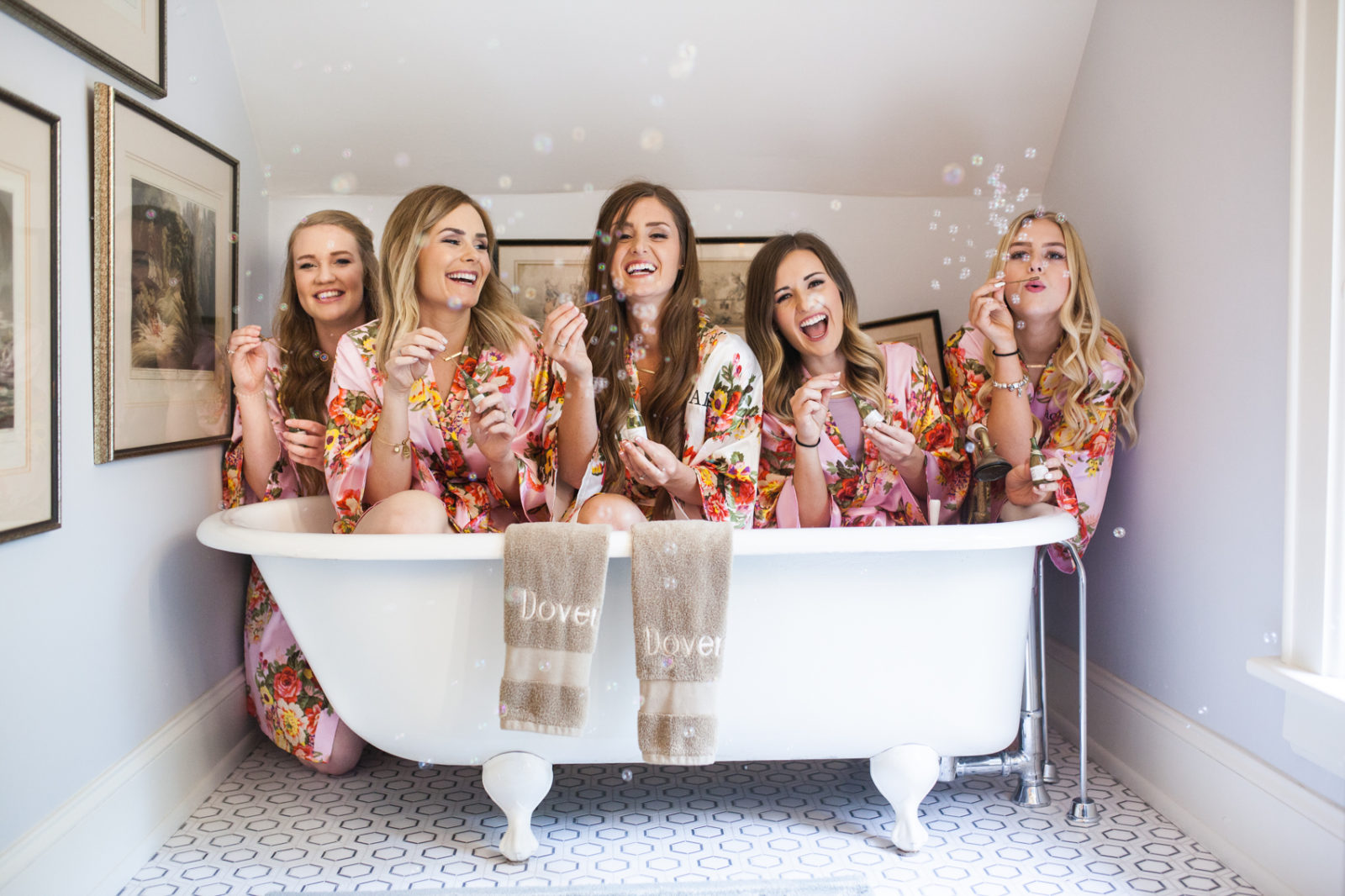 bridesmaids blowing bubbles in a claw foot bath tub