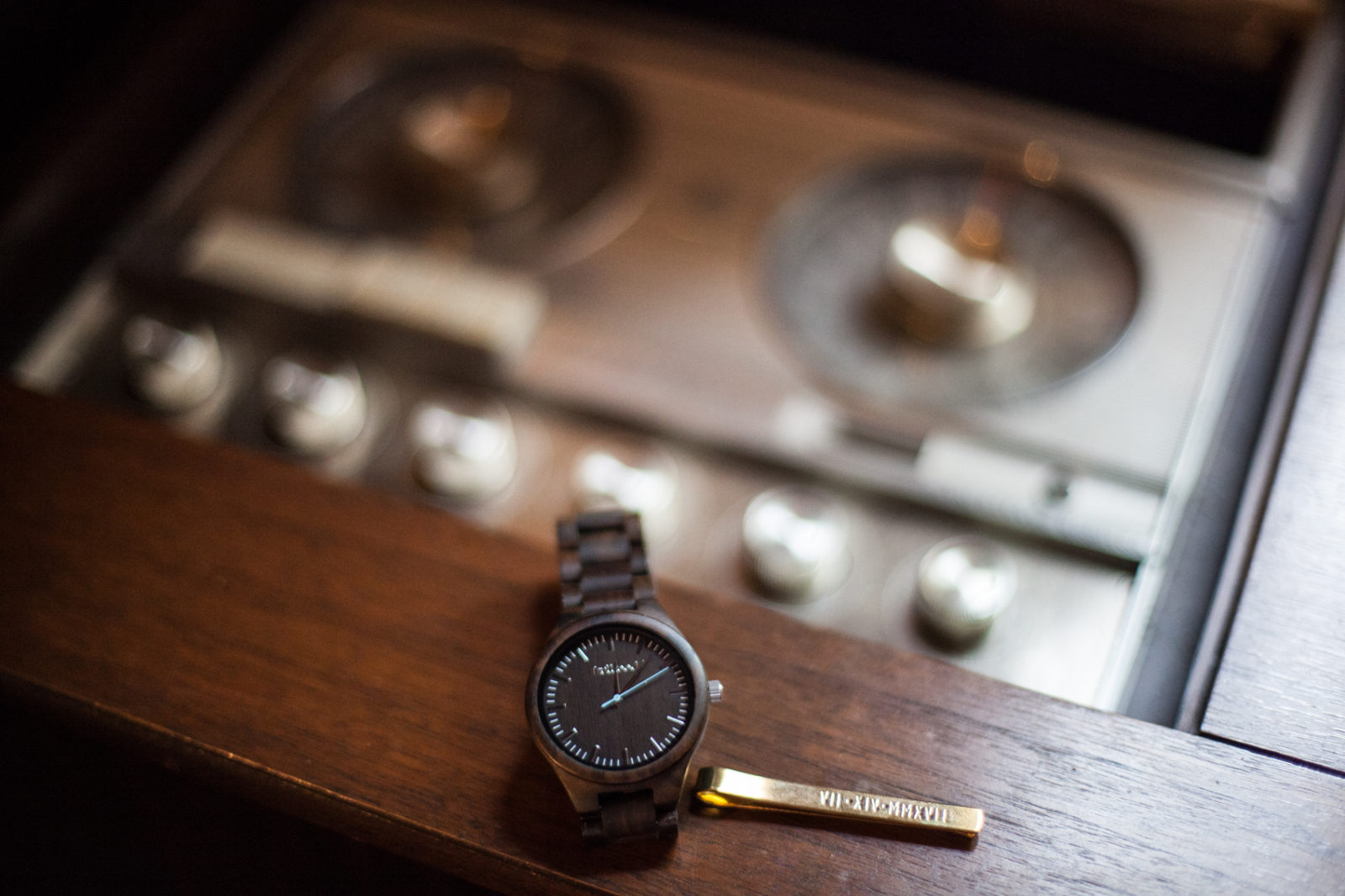 grooms watch and tie bar clip on top of vintage music player