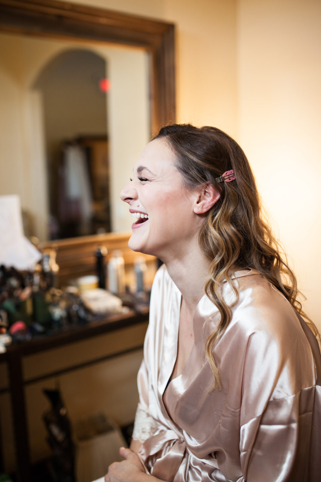 bride laughing while getting ready for wedding day