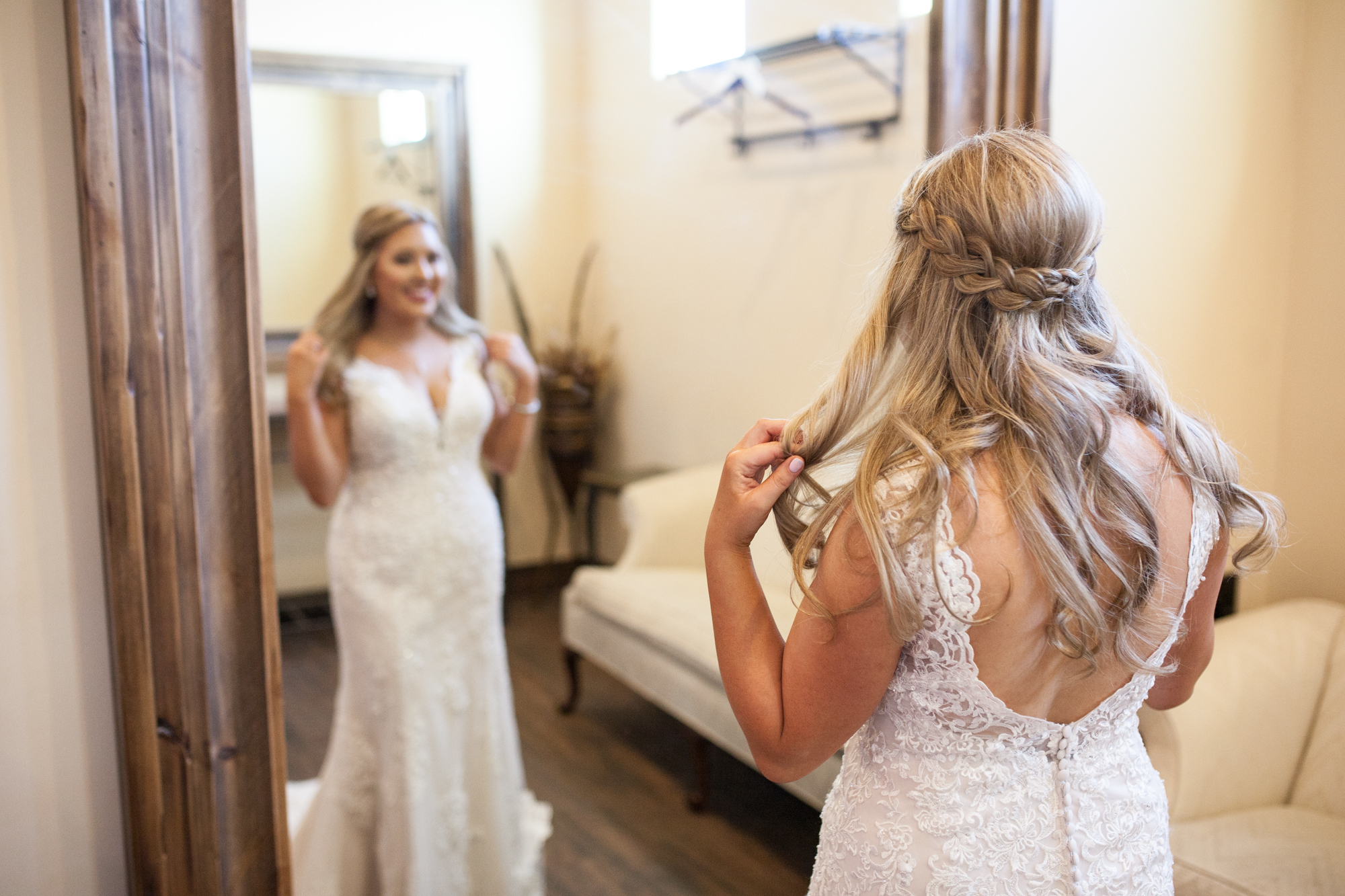 bride in her wedding dress looking in the mirror