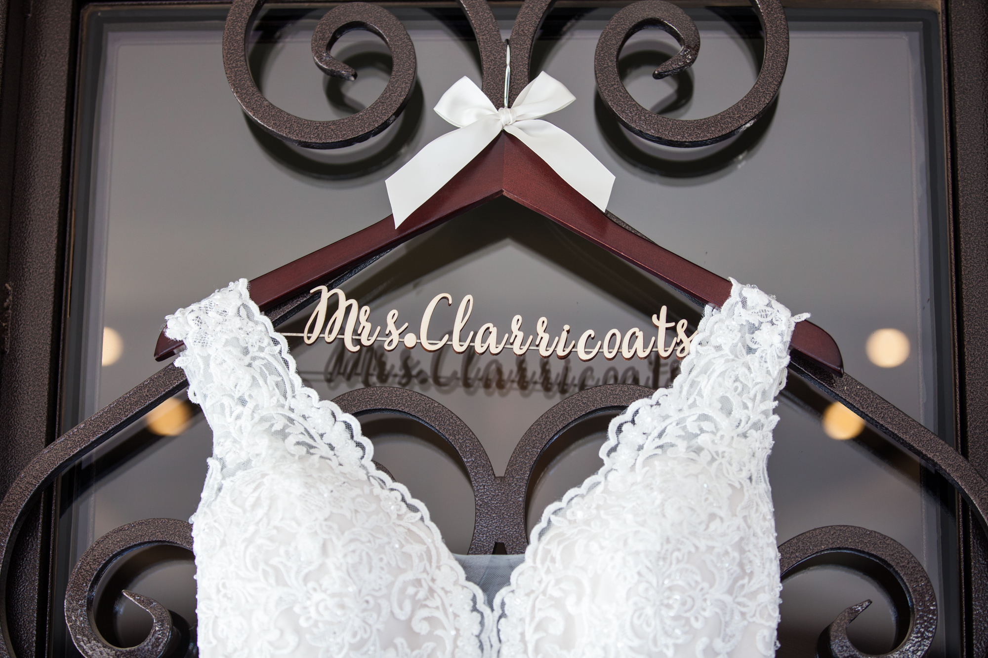 wedding dress hanging on wooden hanger with last name