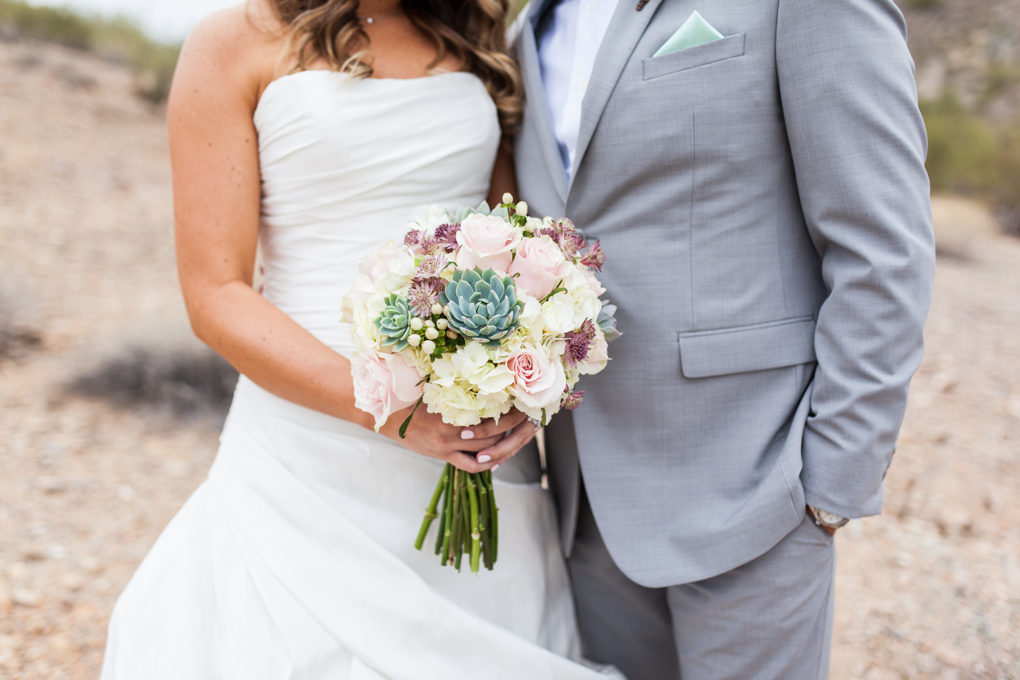bride and groom with succulent wedding bouquet with pink roses