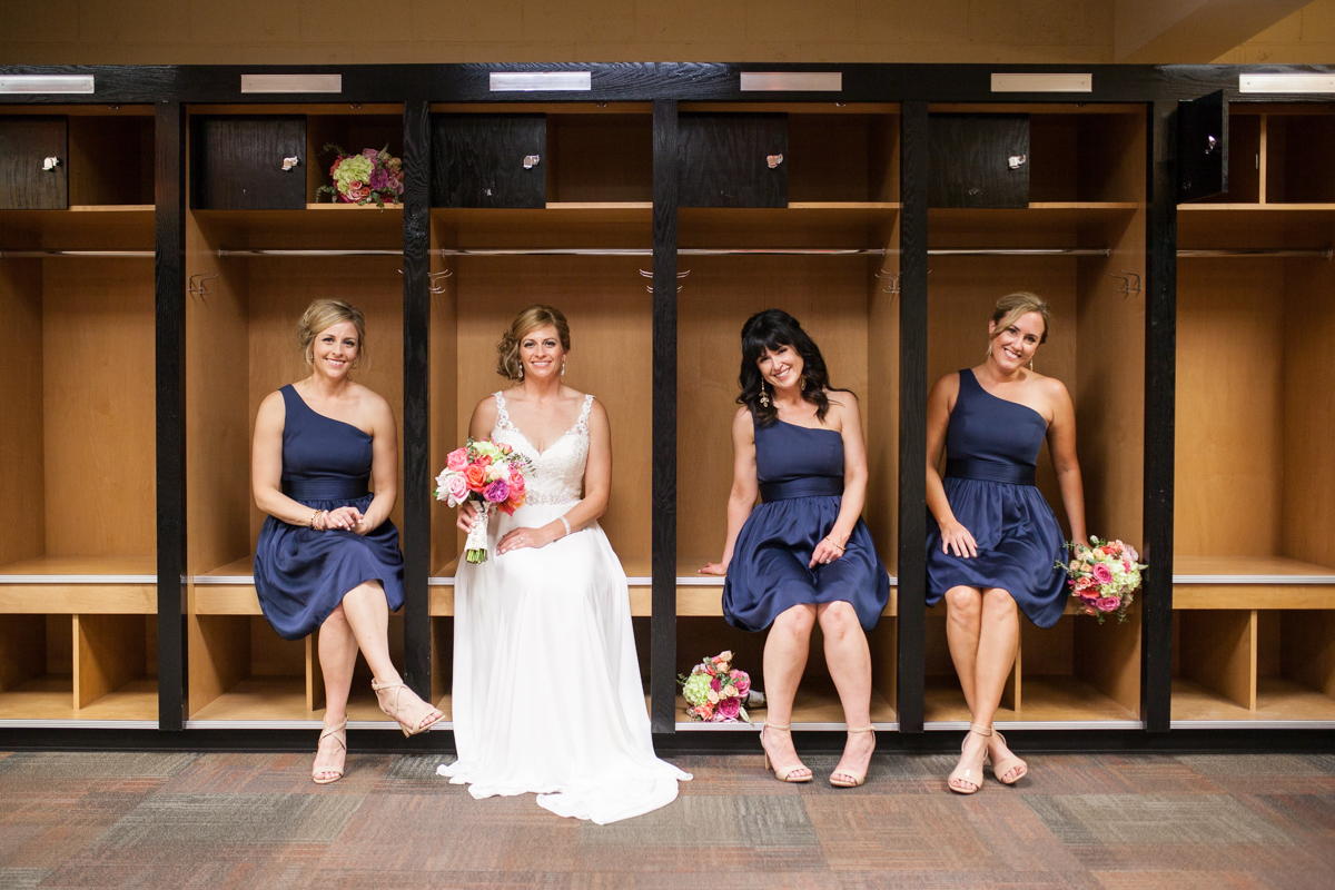 bride and bridesmaids in baseball locker room