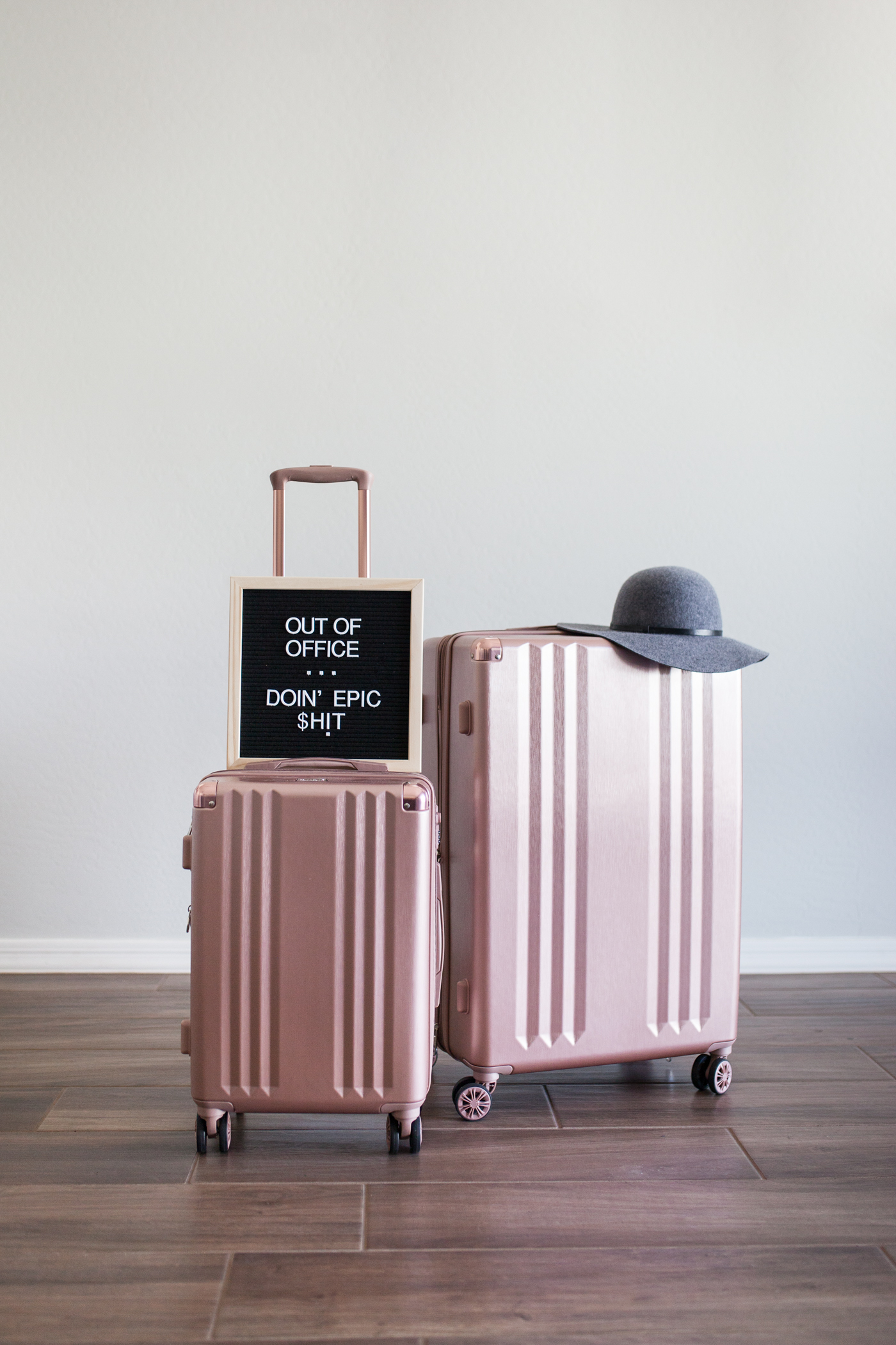 Calpak rose gold luggage set and felt letter board that says out of office: doin' epic shit