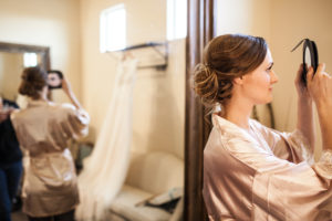bride looking in mirror on wedding day