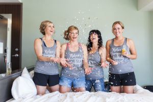 bride and bridesmaids throwing confetti on wedding day