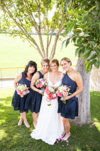 bride with bridesmaids in one shoulder navy blue tea length bridesmaids dresses
