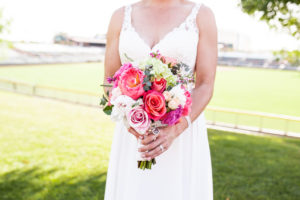 Bride with lace v neck sheath wedding dress with colorful bridal bouquet
