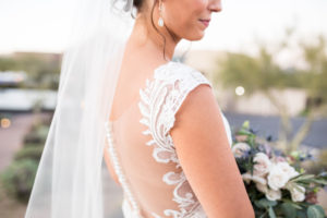 desert wedding bride with large succulent bouquet and lace illusion back wedding dress by eddy k